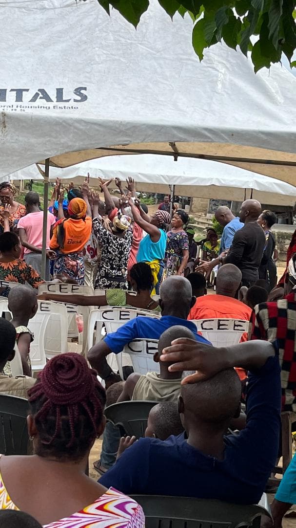 Community members gathered under canopies during a support and awareness session